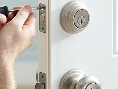 Locksmith fitting a new lock and key on office door